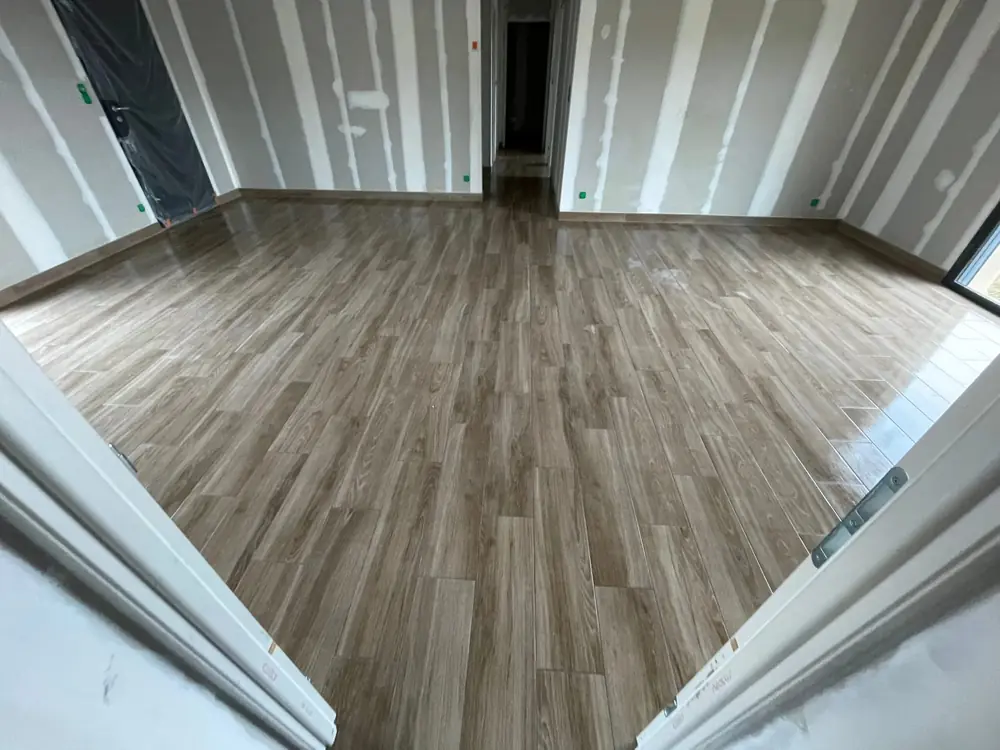 Carrelage imitation parquet gris nuancé posé à joints décalés dans une pièce en placo