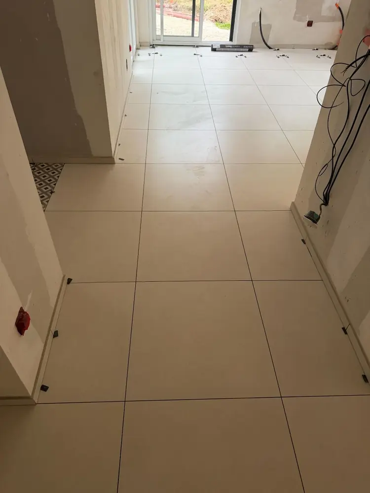 Enfilade de pièces en carrelage grand format beige avec joints alignés d'une pièce à l'autre