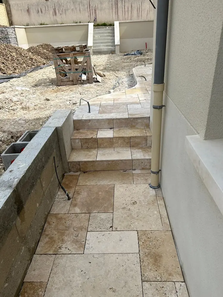 Escalier extérieur et allée en travertin opus le long d'une maison neuve, près de Chartres