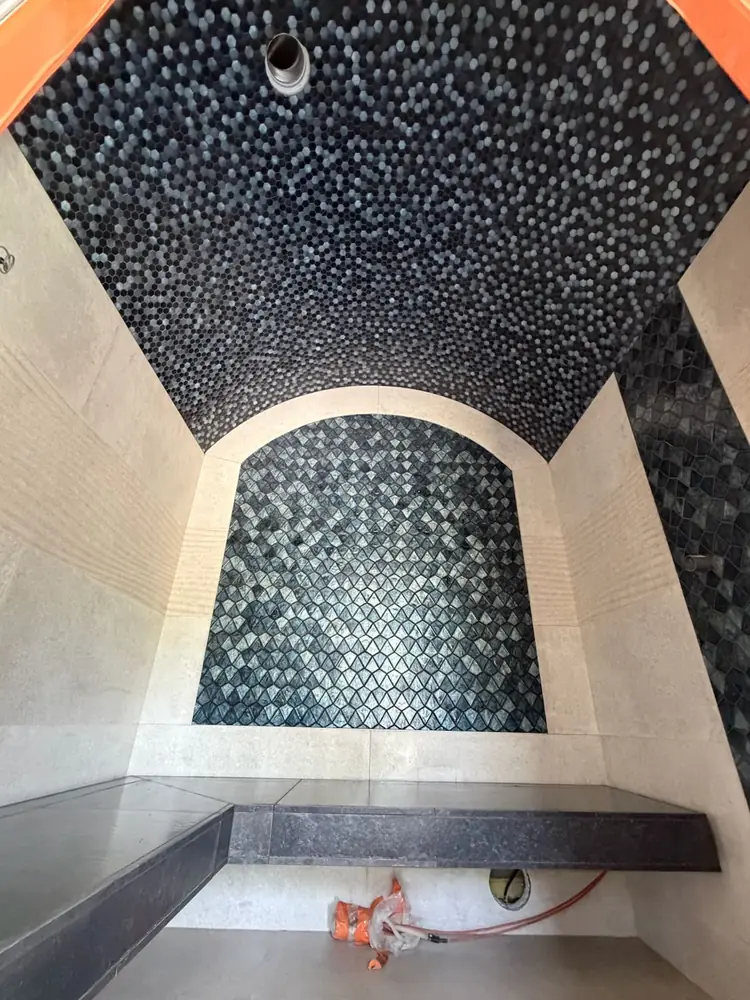 Voûte de hammam entièrement habillée de mosaïque, banc d'angle en pierre noire
