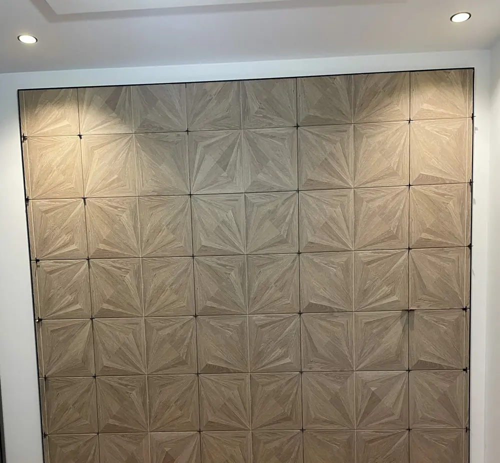 Mur décoratif en carreaux à motif marqueterie de bois, croisillons en place avant les joints