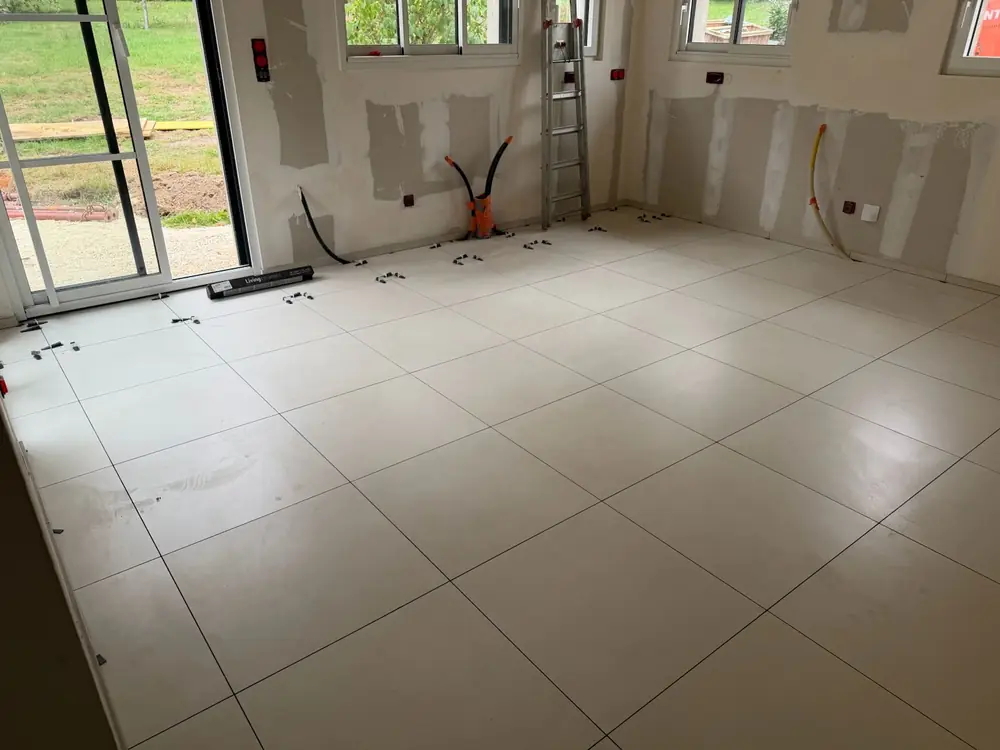 Pièce de vie avec baie vitrée et sol en carrelage grand format beige