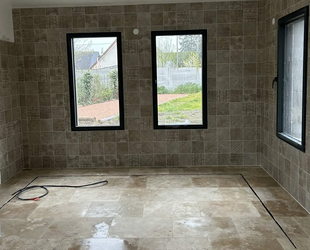 Murs carrelés en carreaux effet pierre vieillie à décors autour de deux fenêtres noires
