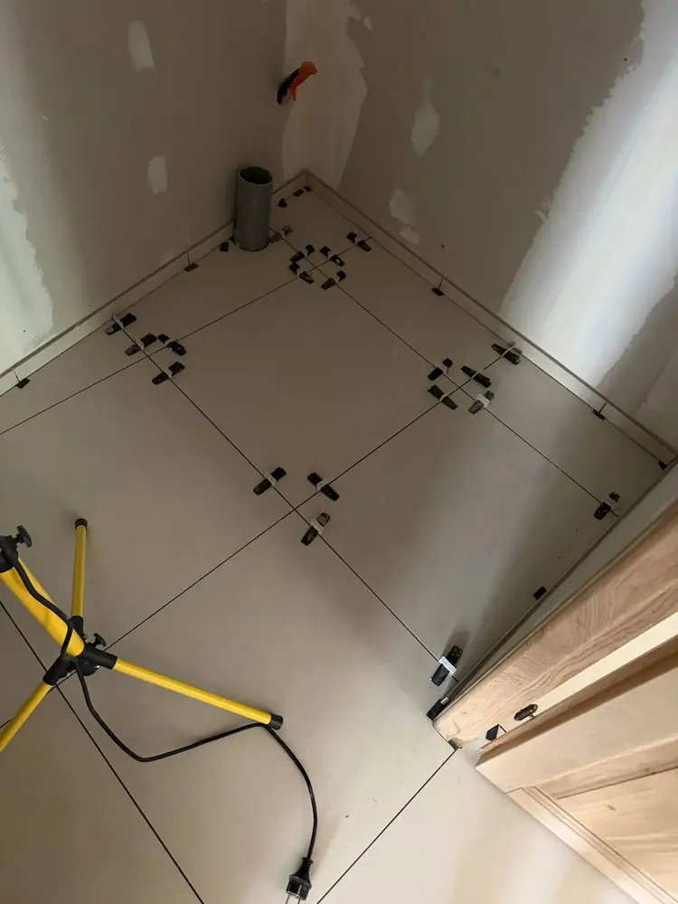 Pose de carrelage grand format beige avec système de calage autonivelant