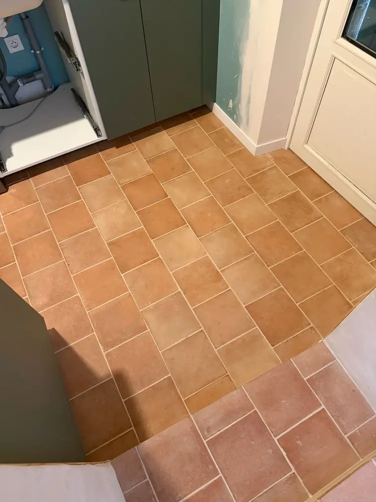 Raccord de seuil entre deux sols en carreaux aspect terre cuite au pied d'une cuisine