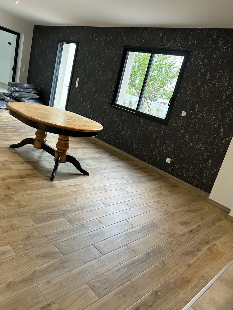 Séjour en carrelage imitation parquet chêne posé à joints décalés, table en bois